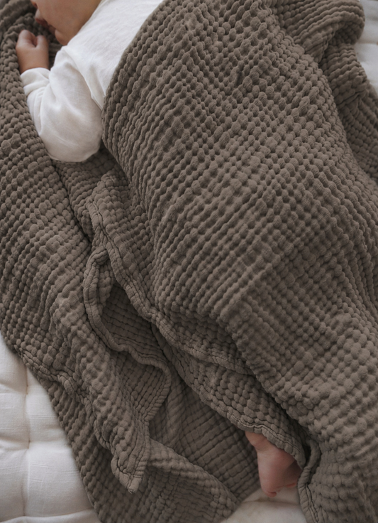 Baby wrapped in a our Kadera 4-layer Muslin Swaddle