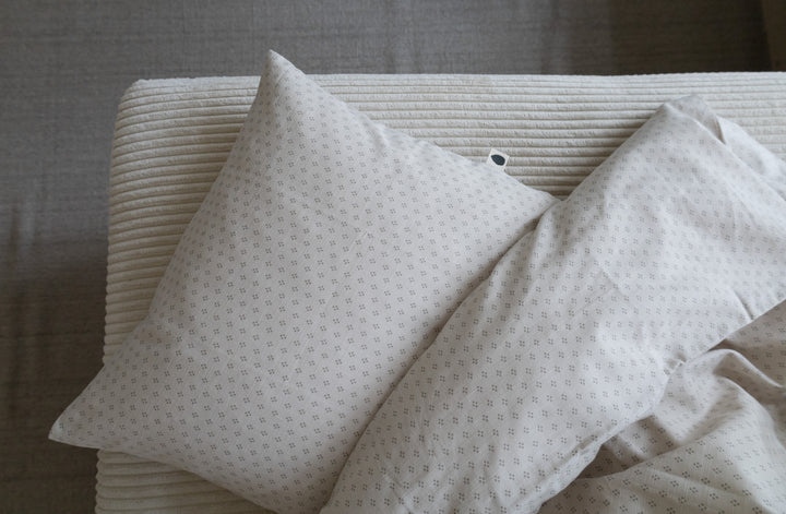 Lucca Baby Bedding in Natura Dot arranged on a bed