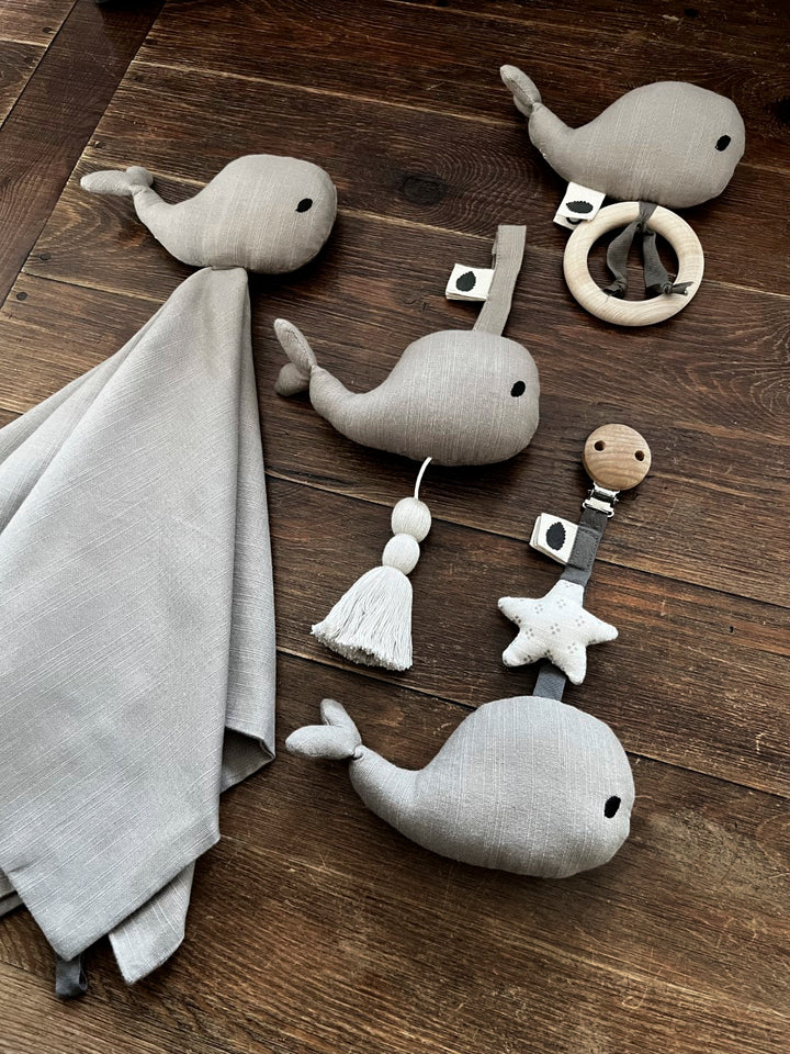 Assorted grey Waldo baby toys arranged on a wooden floor